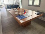 une grande table en bois sur laquelle sont posés des papiers, dans un bureau
