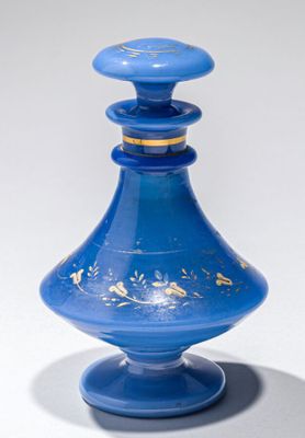 une bouteille en verre bleue ornée d'un motif doré