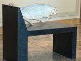 a sculpture of a fish on a bench in a room