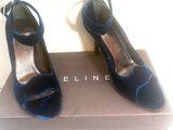une paire de chaussures bleues posée sur une boîte, elle-même posée sur une surface blanche