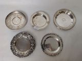 six silver plated dishes on a table with a mirror