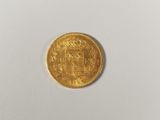 a close up of a gold coin on a white surface