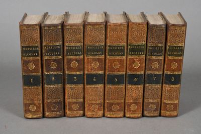 six old books are lined up in a row on a gray surface