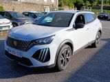 Le SUV blanc est garé sur le parking, à côté d'autres voitures.