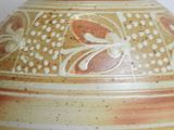 a brown vase with a flower design on it