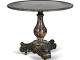 une table ronde avec un piètement en métal et un plateau en marbre