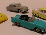 plusieurs petites voitures sont alignées sur une surface blanche