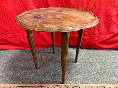 une petite table avec un plateau en bois posée sur un tapis