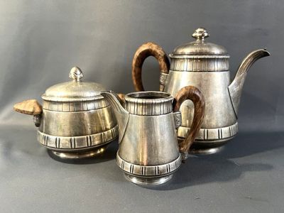 three silver teapots sitting on a table