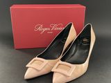a pair of nude colored shoes with a box in the background