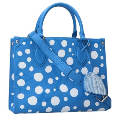 a blue and white polka dot purse with a tassel
