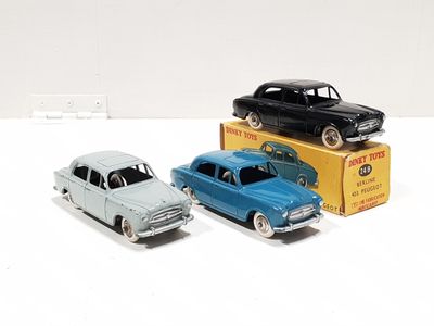 three toy cars sitting next to each other on a white surface