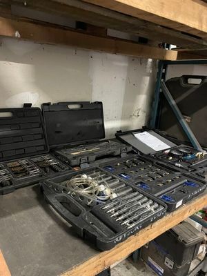 de nombreux outils qui prennent la poussière sur une étagère dans le garage