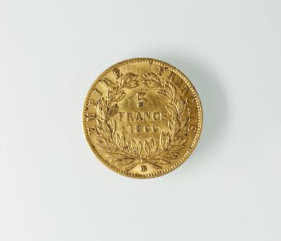 gros plan d'une pièce d'or sur une surface blanche