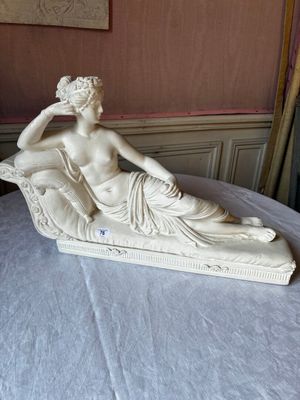 a statue of a woman sitting on top of a bed