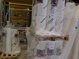 de nombreux rouleaux de papier empilés sur des palettes dans un entrepôt
