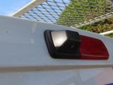 a close up of a red and white light on the back of a white truck
