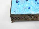 a blue box with blue beads on it sitting on a table