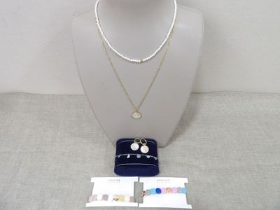 un mannequin blanc portant un collier et un sac à main