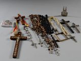 a lot of rosary and other religious items laid out on a table