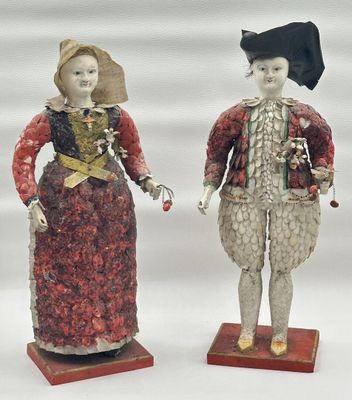 deux figurines d'un homme et d'une femme debout l'un à côté de l'autre