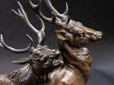 a bronze statue of two deers that are standing next to each other