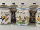 four ceramic containers with horses and horses on them sitting on a table