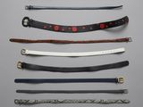 six different types of leather belts on a gray background