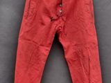 un vieux pantalon rouge suspendu à un portant