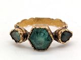 une image d'une bague en or avec une pierre verte