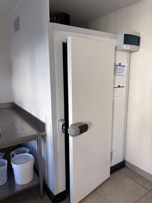 a white refrigerator in the corner of a kitchen