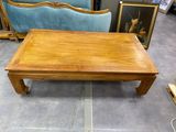 une table basse en bois avec un canapé bleu en arrière-plan