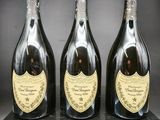 trois bouteilles de champagne posées sur une table noire