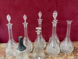 quatre vases en verre posés sur une table avec un fond rouge