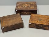 trois boîtes en bois posées les unes à côté des autres sur une table