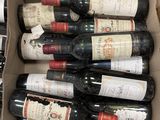 Les bouteilles de vin se trouvent dans un carton posé sur une table.