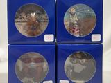four boxed christmas ornaments in blue boxes on a white background