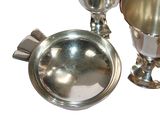 a silver cup and a silver plate on a table