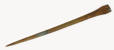 une vieille batte de baseball en bois avec un manche en métal, posée sur une surface blanche