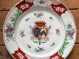 une assiette ornée d'un blason, posée sur une table en bois