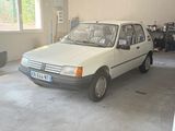 une petite voiture blanche garée dans un garage près d'une fenêtre