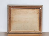 an old picture frame sitting on top of a wooden shelf