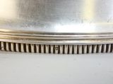 une assiette en argent posée sur une table, sur laquelle figure un numéro