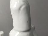 a figurine of a man holding a cup and a vase