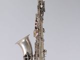 an image of a silver saxophone on a gray background