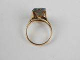 an image of a gold ring with a blue topaz stone