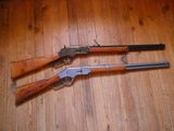 deux armes à feu posées l'une à côté de l'autre sur un plancher en bois
