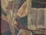 un vieux tableau représentant une femme tenant un livre entre ses mains