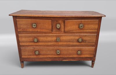 une commode ancienne à quatre tiroirs, dotée de boutons en laiton