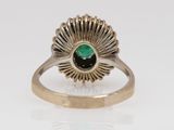 a close up of a gold ring with a green stone